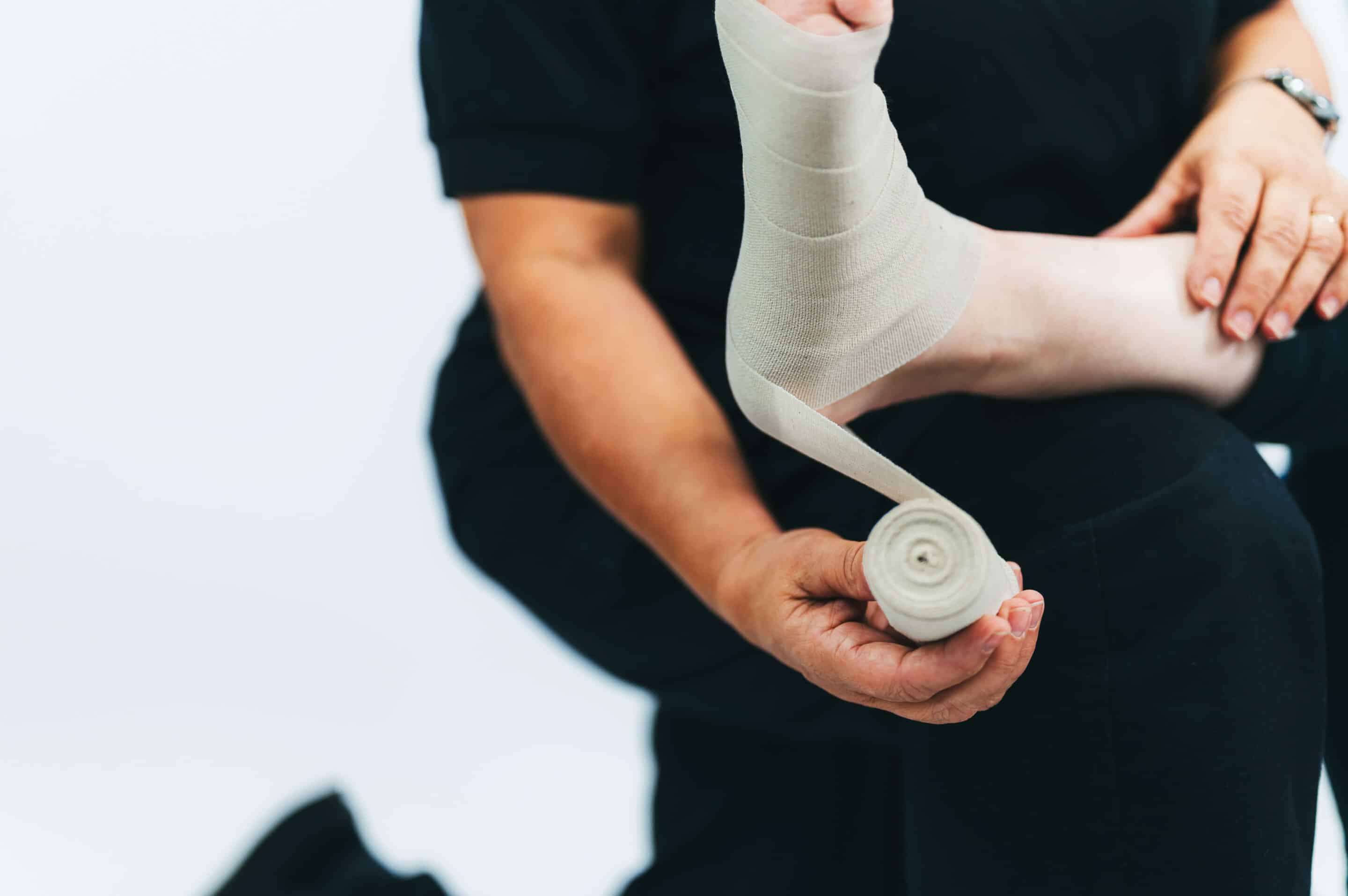 Closeup of doctor wrapping bandage around persons foot